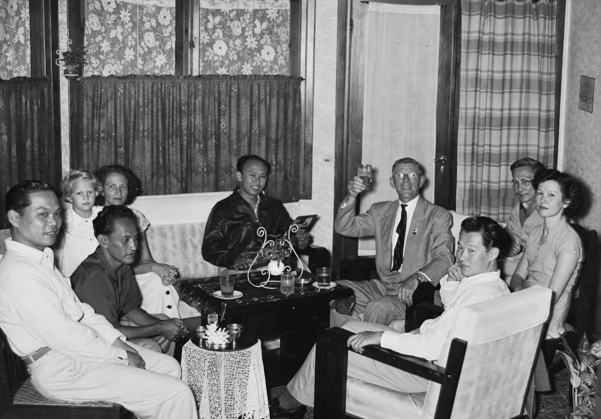 Ruang tengah rumah Jl. Buton No. 11 &mdash; sofa kulit hijau di depan perapian, saksi puluhan tahun obrolan sore